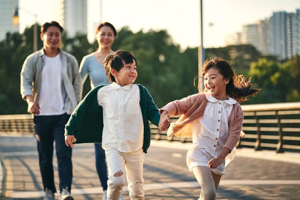 happy family with two children walking on pedestrian bridge