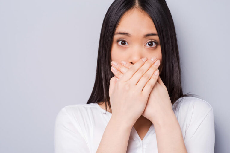 Young woman covering mouth with hands