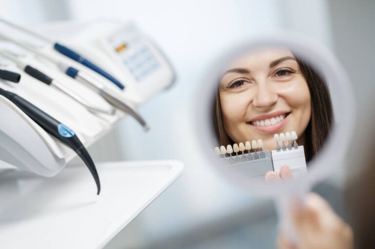 young girl in dental clinic looking at reflection of her smile in the mirror