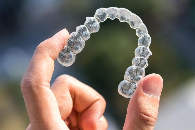 Hands Holding Invisalign braces